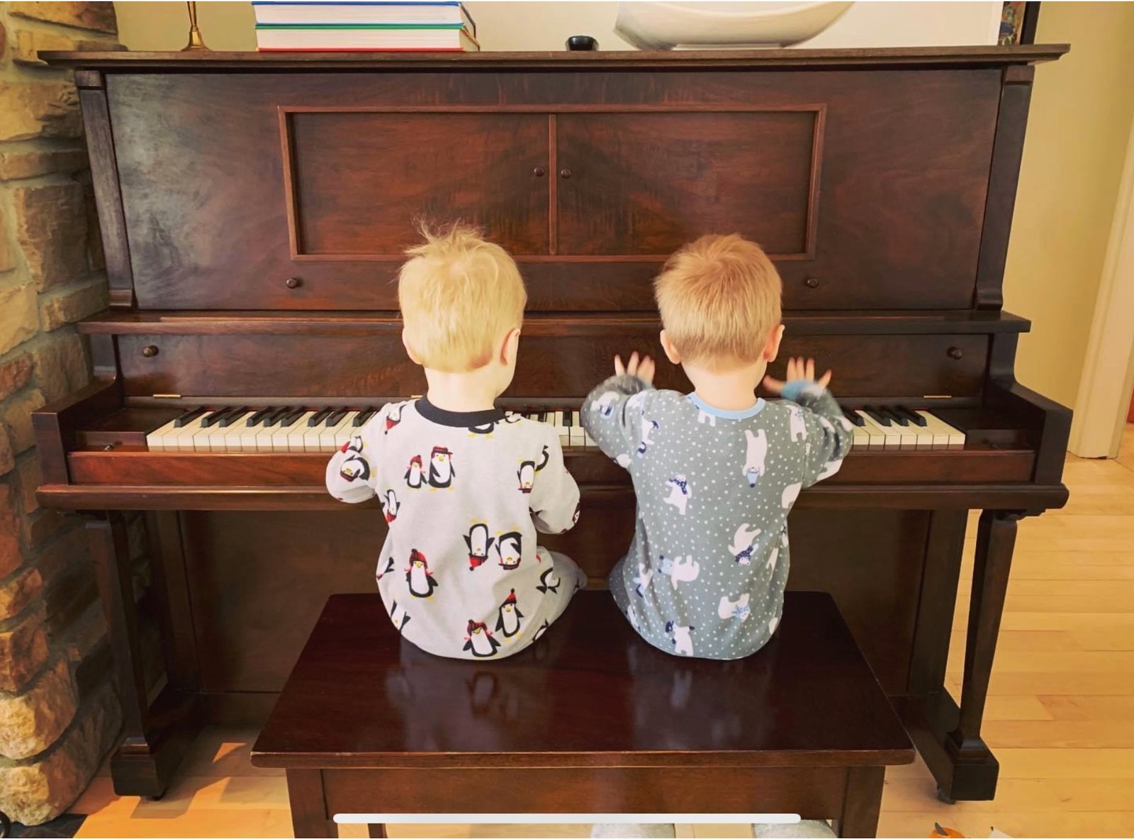 Deux enfants jouent du piano sur un piano antique
